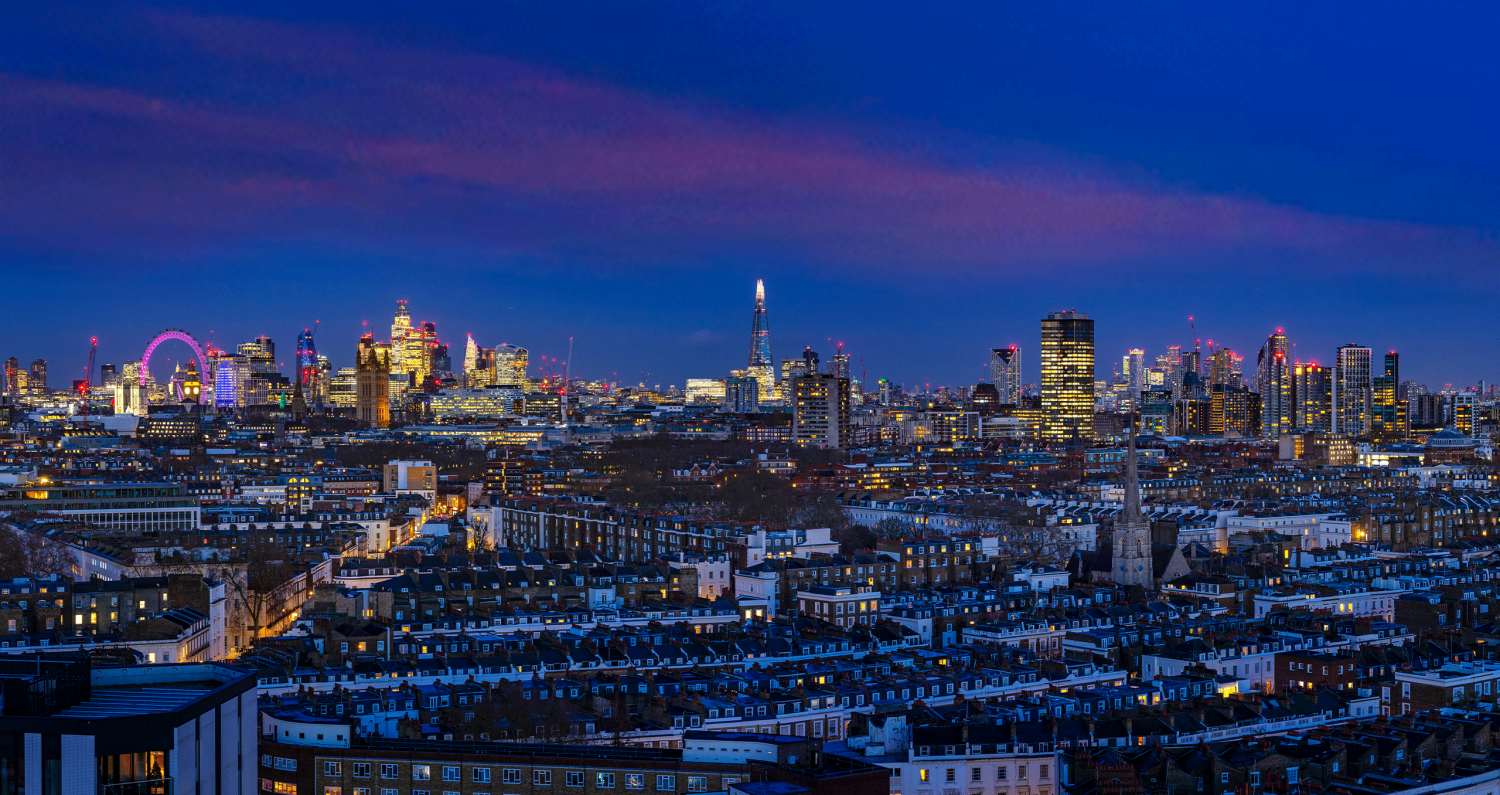 London city skyline at dusk from 16th floor looking out towards the London Eye, The Shard and Canary Wharf